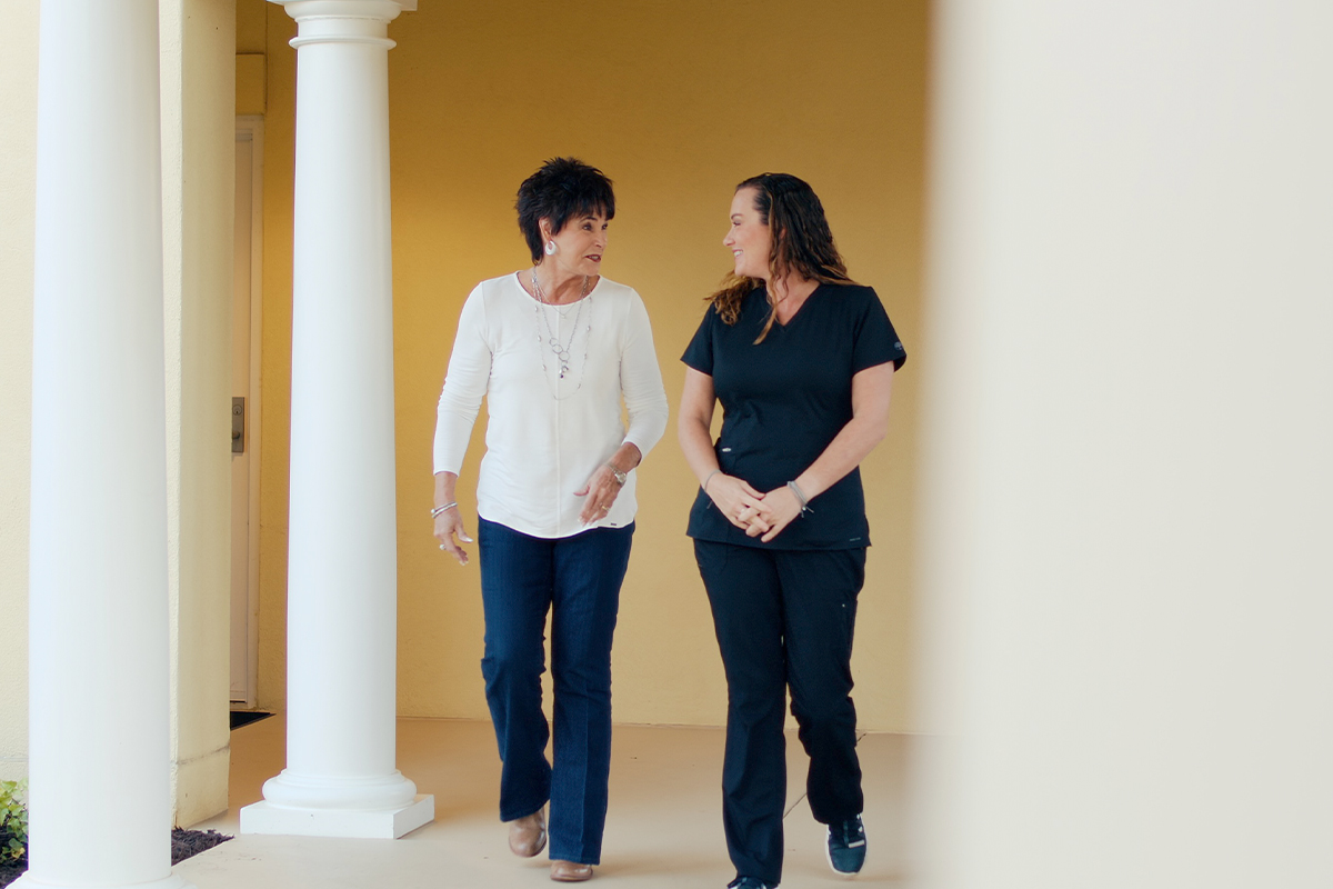 woman walking with team member after liposuction in Gulf Shores, AL